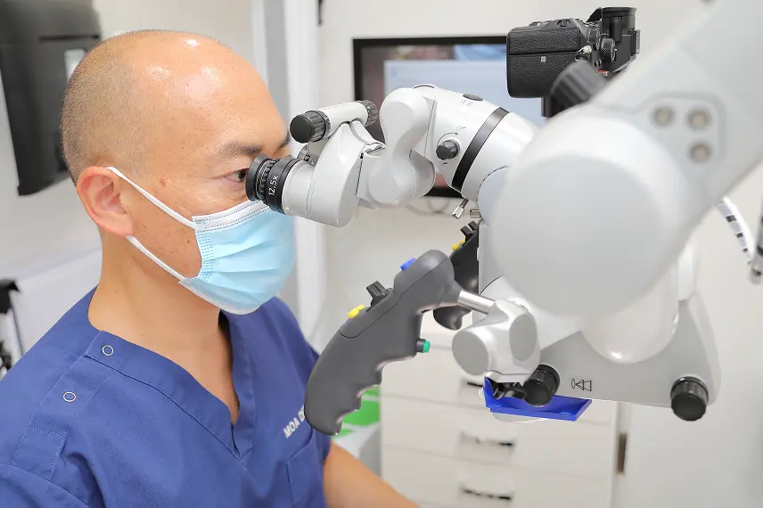 マイクロスコープを使用する院長