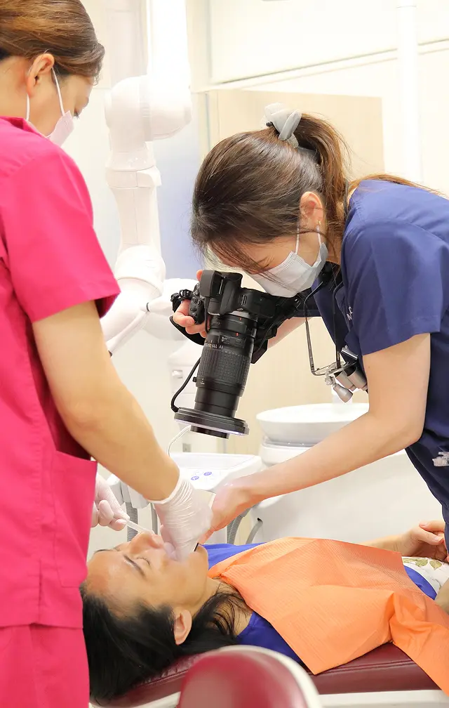 田中さやか副院長とスタッフが治療をしている写真